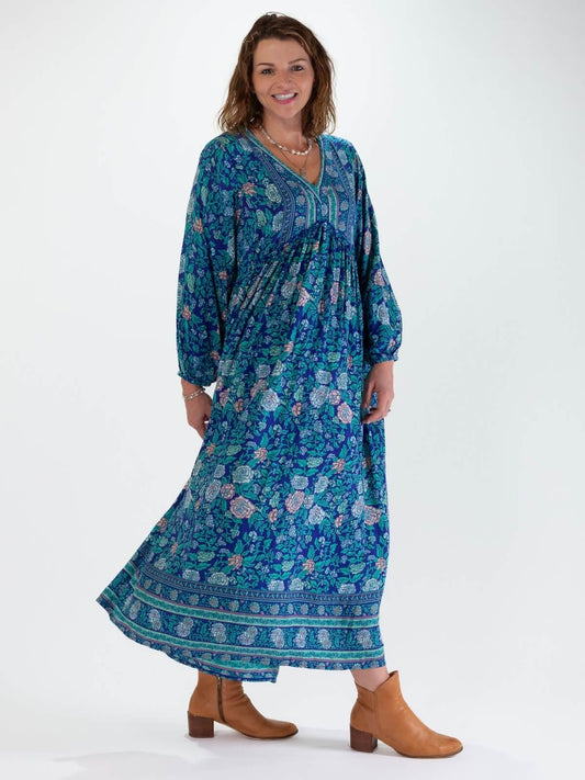 Woman wearing a blue floral boho maxi dress on a white background