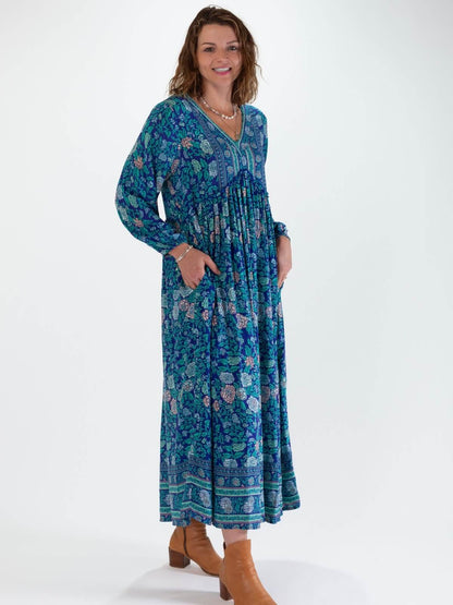 Woman wearing a blue floral boho maxi dress on a white background